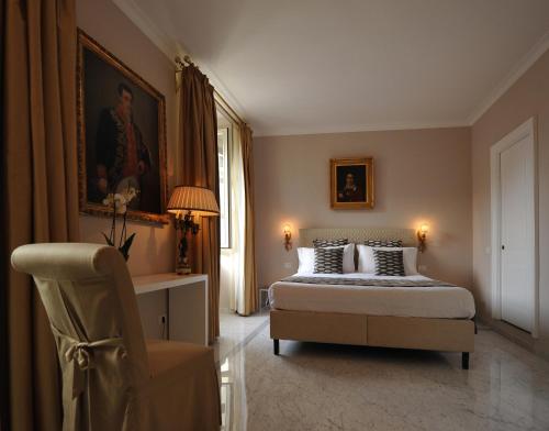 a bedroom with a bed and a chair in it at Angel Spagna Suite in Rome