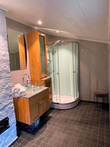 a bathroom with a glass shower and a sink at Svolvær Minihouse in Kongsmarka