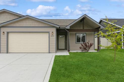 a house with a garage and a grass yard at Destiny Cove in Kalispell
