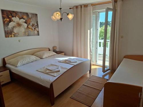 a bedroom with a large bed and a balcony at Apartmani Dijana in Rab