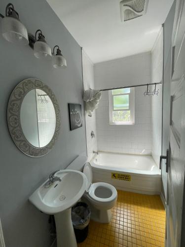 a bathroom with a sink and a toilet and a tub at Vancouver east downtown queen bed room share bathroom in Vancouver