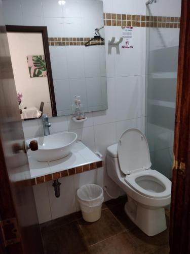 a bathroom with a toilet and a sink at Finca Hotel La Playa Villeta in Villeta