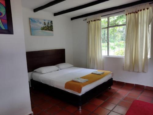 a bedroom with a bed and a window at Finca Hotel La Playa Villeta in Villeta