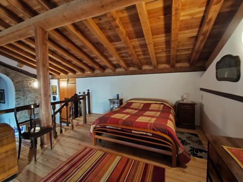 a bedroom with a bed and a wooden ceiling at La Baita nel Bosco in Berzo