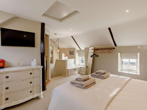 a bedroom with two beds and a dresser with towels at 1 Bed in Stamford oc-92406 in Ketton