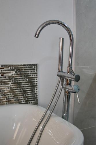a bathroom with a sink and a faucet at Greenlake Guesthouse in Maseru
