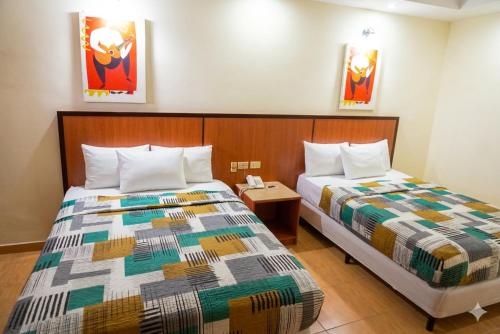 ein Hotelzimmer mit zwei Betten und einem Tisch in der Unterkunft Express Inn Coronado & Camping in Playa Coronado