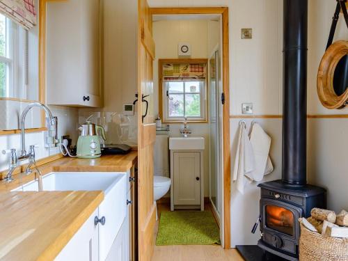 a kitchen with a wood stove in a bathroom at 1 Bed in Aylesbury oc-76403 in Ludgershall