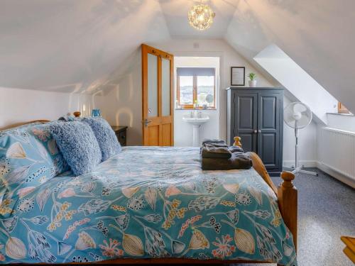 a bedroom with a bed with a blue comforter at 1 Bed in Lydney oc-43724 in Lydney