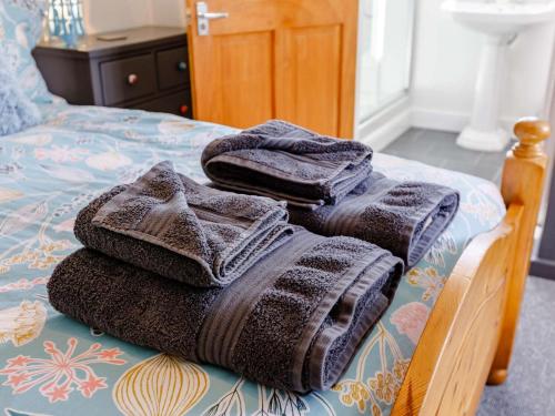 a pile of towels sitting on top of a bed at 1 Bed in Lydney oc-43724 in Lydney