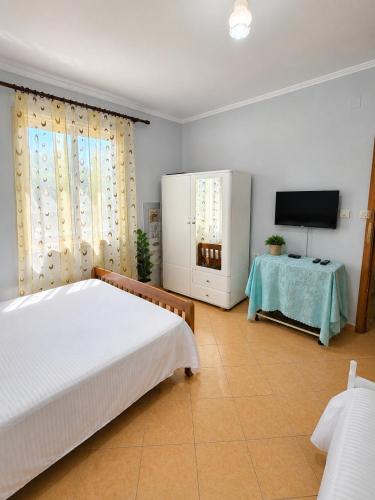 a bedroom with a bed and a tv and a table at Garden Oasis in Vlore in Vlorë
