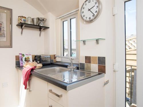 a kitchen with a sink and a clock on the wall at 1 Bed in Riding Mill oc-cn063 in Corbridge