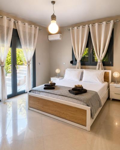 a bedroom with a large bed with two towels on it at Villa Rose Ground Floor - Private Swimming Pool Garden in Koskinou