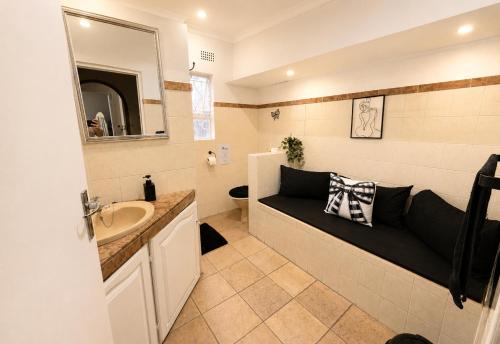 a bathroom with a black couch in the corner of it at Zhantique Guest House 2- Unit 11 in Boksburg