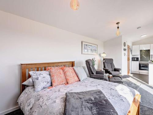 a bedroom with a large bed and two chairs at 1 Bed in Weymouth oc-82099 in Osmington