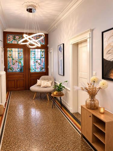 a living room with a chair and stained glass windows at KVS concept Écommoy chambres haut de gamme proche circuit 24 heures Le Mans in Écommoy