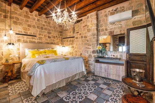 a bedroom with a bed and a stone wall at George & Alexandra's Apartments in Rhodes Town