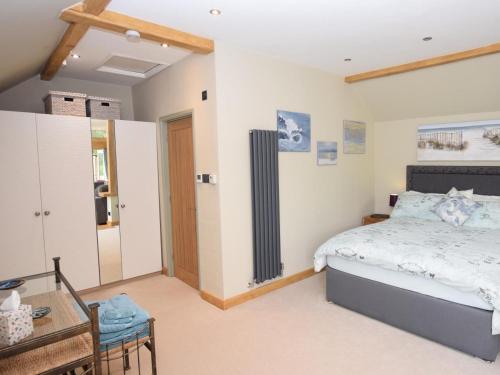 a bedroom with a bed and a table and a mirror at 1 Bed in Lymington oc-50723 in Sway