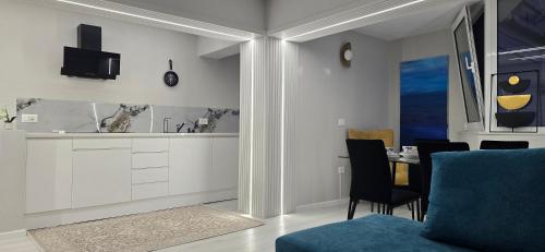 a living room with a blue couch and a table at Promenade Apartment ,Sea view in Durrës