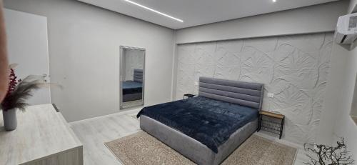 a bedroom with a bed and a wall with leaves on it at Promenade Apartment ,Sea view in Durrës