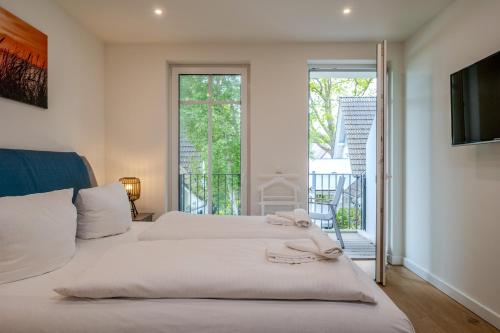 a bedroom with two beds and a balcony at Strandhaus Zingst Apartment 11 in Zingst
