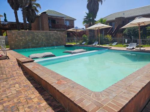 a large swimming pool with blue water in a yard at Myoli Beach Breeze in Sedgefield
