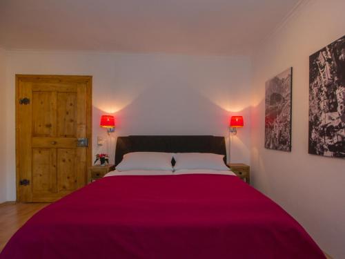 a bedroom with a large bed with a red blanket at Altstadt Ferienwohnung Guade Zeit in Füssen