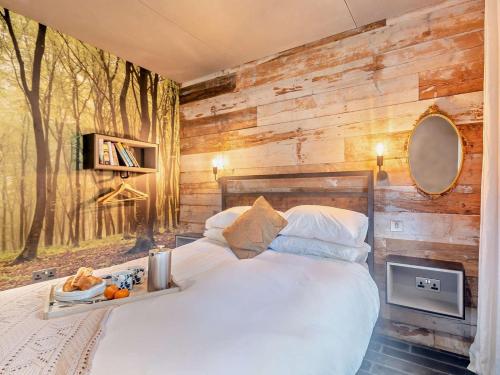 a bedroom with a bed with a wooden wall at 2 Bed in Lymington oc-95021 in Brockenhurst