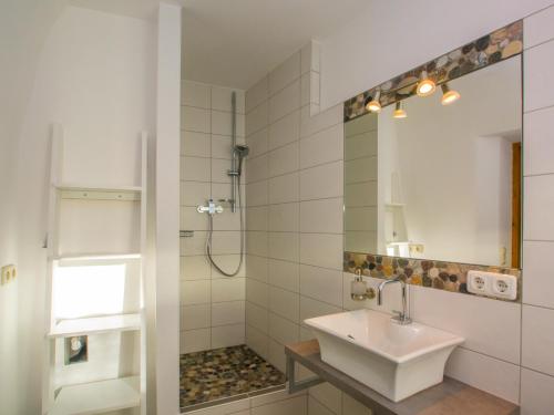 een witte badkamer met een wastafel en een douche bij Altstadt Ferienwohnung Guade Zeit in Füssen