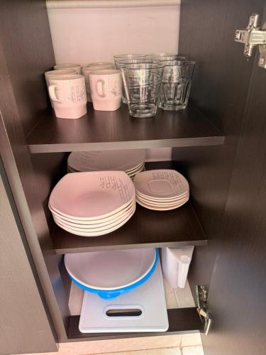 a cupboard with plates and bowls and dishes on at Apartahotel Paraíso Cafetero Guaduales del café 401B in Montenegro