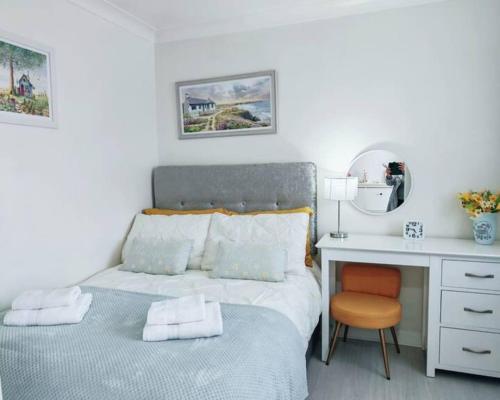 a small bedroom with a bed and a desk at Fully accessible bungalow by the Beach in Port Talbot