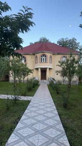 a walkway leading to a large yellow house at Gabala villa in Gabala