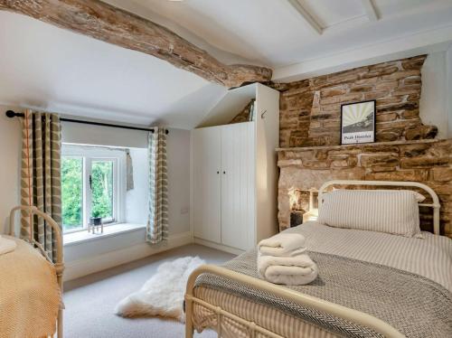a bedroom with a bed and a stone wall at 2 Bed in Hope Valley oc-88979 in Sheffield