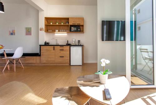 a living room with a table and a kitchen at Coastline Studio Apartment Ligia Bay in Lygia