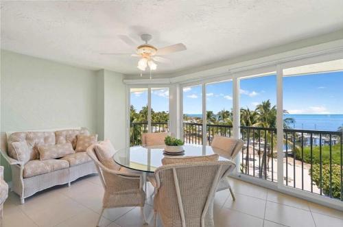 a dining room with a table and chairs and a balcony at Islamorada Oceanfront Luxury Living in Islamorada