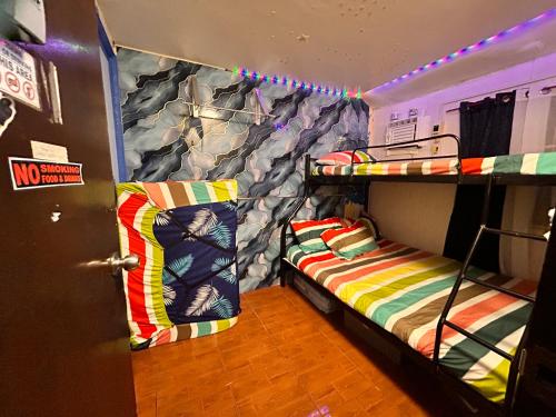 a room with two bunk beds and a door at MG 5pax 1 AC BR 300mbps FREE Netflix Parking Cignal Videoke Shower Heater Cook & Grill in Rodriguez