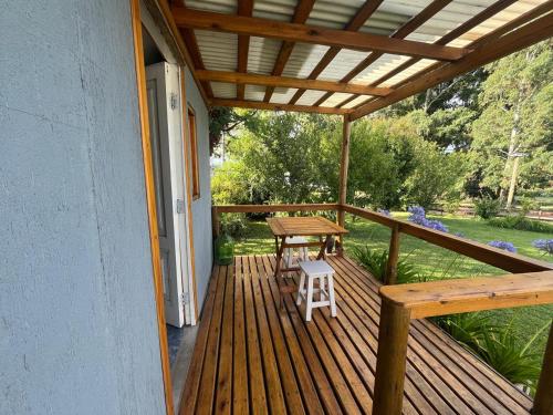 a wooden deck with a picnic table and a bench at Sierras de Canela Tiny in Tandil