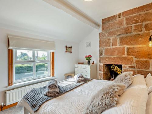 a bedroom with a bed and a brick wall at 2 Bed in Kelsall oc-94445 in Kelsall