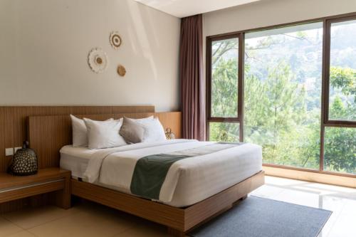 a bedroom with a bed and a large window at Hikari Hill View Villa 7 Bedrooms With a Private Swimming Pool and a Billiard Table in Bandung