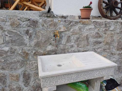 a stone wall with a white bench against a stone wall at Apartmaji Karbic in Postojna