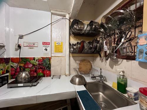a kitchen with a sink and some pots and pans at MG 5pax 1 AC BR 300mbps FREE Netflix Parking Cignal Videoke Shower Heater Cook & Grill in Rodriguez
