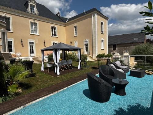 a backyard with a gazebo and chairs and a pool at KVS concept Écommoy chambres haut de gamme proche circuit 24 heures Le Mans in Écommoy