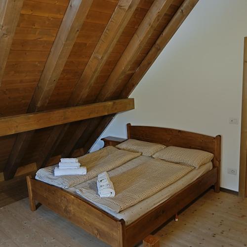 a bed with two towels on it in a attic at Stanza Cuori Malga Ciauta in Villanova