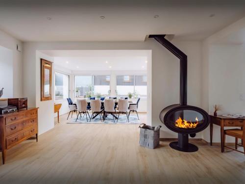 a living room with a fireplace and a table with chairs at Villa Le Cep - OVO Network in Menthon-Saint-Bernard