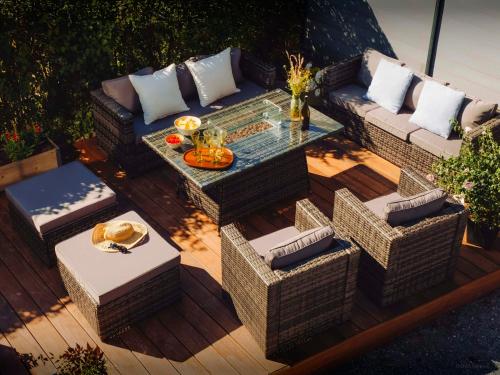 an outdoor patio with a table and wicker chairs at Villa Le Cep - OVO Network in Menthon-Saint-Bernard