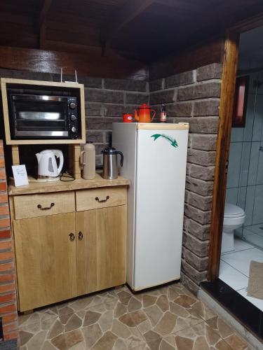 a small kitchen with a refrigerator and a microwave at Cabanasdoaconchego in São Salvador
