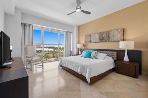 a bedroom with a bed and a desk and a television at Luxury Beach Condo with Resort Access Vidanta in Nuevo Vallarta