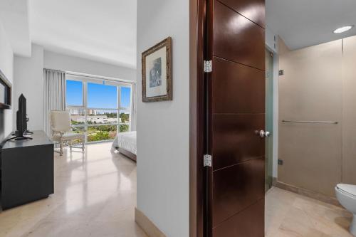 a bathroom with a door leading to a bedroom at Luxury Beach Condo with Resort Access Vidanta in Nuevo Vallarta
