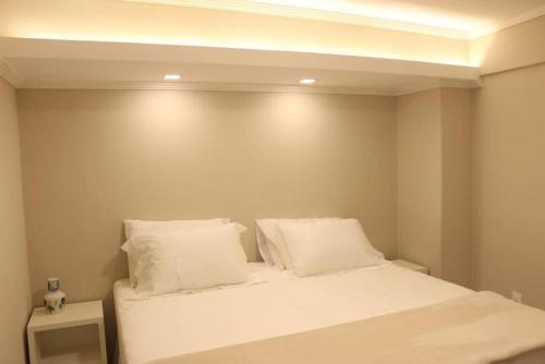 a bedroom with a bed with white sheets and pillows at Casa da Ópera in Diamantina