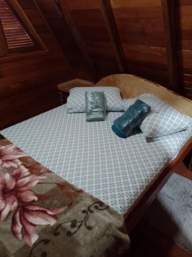 a bed in a room with a blue and white mattress at Cabanasdoaconchego in São Salvador